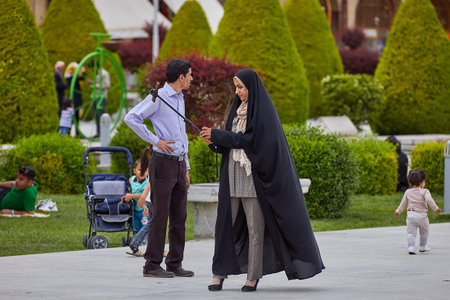 Isfahan, Iran - April 24, 2017: The Iranian family photographs themselves in the Naghsh-e Jahan Square, using a selfie-stick and a smartphone.のeditorial素材