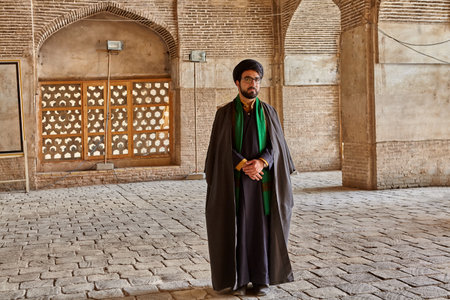 Isfahan, Iran - April 24, 2017: Iranian mullah in traditional clothes stands in the courtyard of the mosque.のeditorial素材