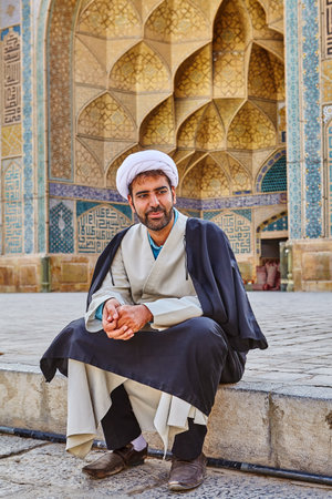 Isfahan, Iran - April 24, 2017: Iranian imam in turban sits in the courtyard of Jame Mosque.のeditorial素材