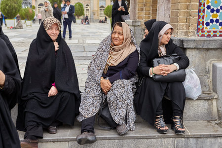 Tehran, Iran - April 27, 2017: Iranian pilgrims in hijab sit near the Shah Abdol Azim Shrine.