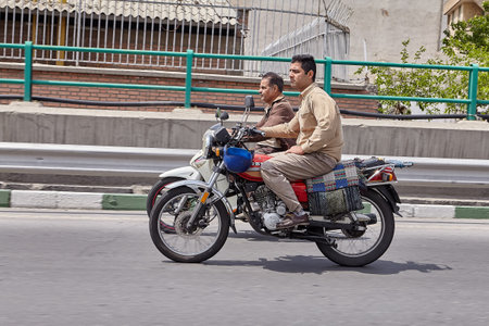 Tehran, Iran - April 28, 2017:  Two motorcyclists without helmets ride along the highway in parallel at high speed.のeditorial素材