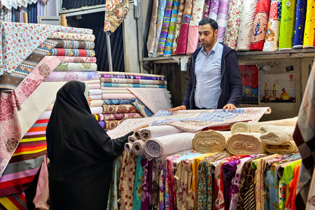 Tehran, Iran - April 29, 2017: Iranian man sells textile to woman in hijab in a fabric shop.のeditorial素材