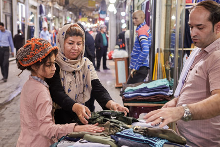 Tehran, Iran - April 29, 2017: Iranian family on Tehran Grand Bazaar, mother and daughter choose clothes in the textile department.のeditorial素材