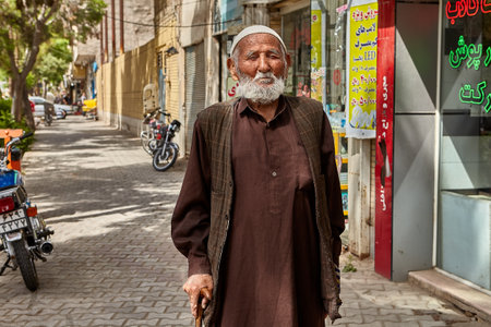 Kashan, Iran - April 27, 2017:  One man of advanced years is walking along the sidewalk of the city street.のeditorial素材