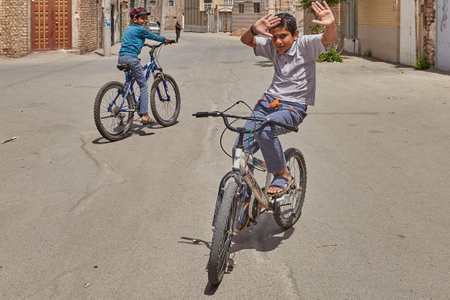 Kashan, Iran - April 27, 2017: An unknown boy teenager shows tricks on a bicycle in the area of private low-rise buildings on the outskirts of the city.のeditorial素材