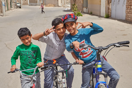 Kashan, Iran - April 27, 2017: Three teenagers on bicycles are posing for a photographer.