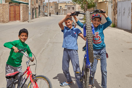 Kashan, Iran - April 27, 2017: Iranian male children play in a deserted street in a quarter of...