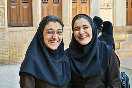 Kashan, Iran - April 26, 2017: two Iranian women in hijab stand in the courtyard in  Tabatabaei historical house and smile.のeditorial素材