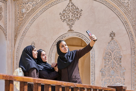 Kashan, Iran - April 26, 2017: three Iranian women in hijab take photos on the phone in Tabatabaei historical house.のeditorial素材