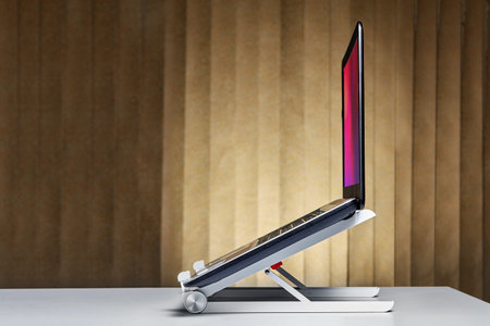 Portable aluminum alloy stand bracket support holder for laptop  set up with notebook on desk.