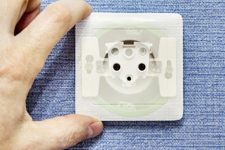 View of the internal module of a household electrical socket through translucent top panel during electrical work.の写真素材