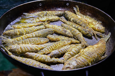 Fried hot fish on the pan just prepared for eating on the nature during hike.の写真素材