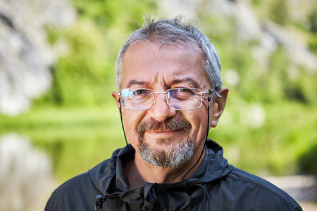 Street portrait of an educated man of Caucasian ethnicity, 56 years old, wearing glasses in a thin...