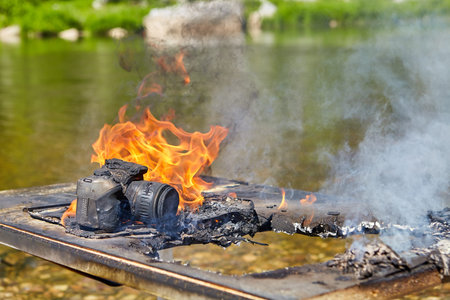 A digital SLR camera with a zoom lens is engulfed in the flames of a forest fire, which spread to...