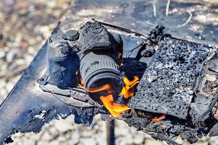 The camera melted and burned during a fire in a camp for hiking tourists, which was caused by a forest fire. An ignited gadget was destroyed by a flame.の写真素材