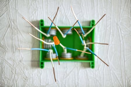 Orange threaded cap or screw-on wire connectors for connecting copper wires in the electrical junction box of home wiring. Shooting with shallow depth of field, blurred background.の写真素材
