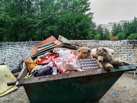 St. Petersburg, Russia - June 9, 2019: Crowded steel dumpster without separate collection of...