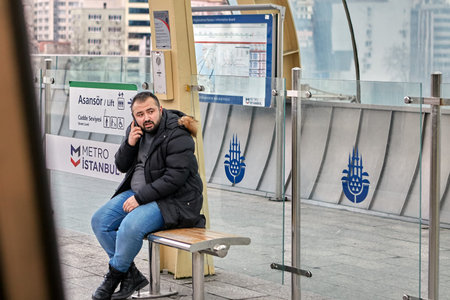 Istanbul, Turkey - February 12, 2020: A male passenger is sitting on a bench at a subway station and...