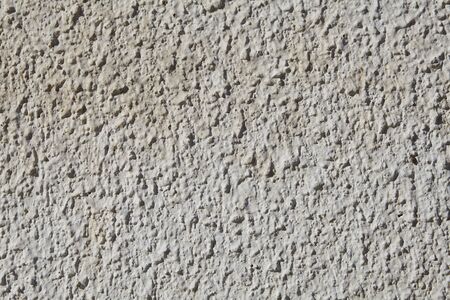 The texture of the coarse grained stucco is off-white in color on the exterior plastered wall.の写真素材