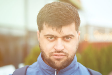 Serious handsome bearded tourist is walking outside at summer.