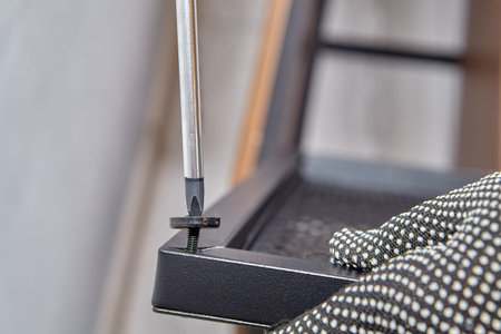 Mounting the magnetic disk at the door metal furniture. Handyman is assembling flat pack shelf by...