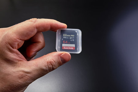 St. Petersburg, Russia - January 9, 2021: Close-up hand holds SanDisk extreme PRO 64GB SDXC memory...