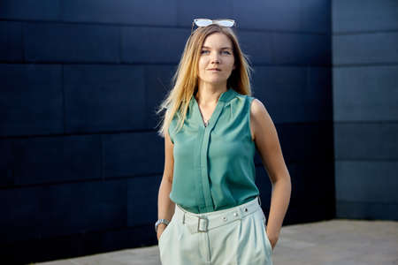 Slender young female stands near business center.の写真素材