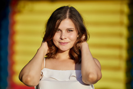 Portrait of young woman 26 years old on bright yellow background.