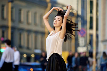 Slim woman in crowd at twilights in summer.の写真素材
