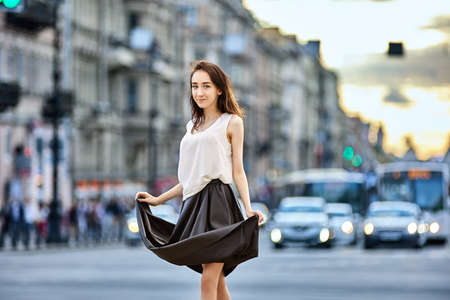 Slim woman stands on street near traffic at daytime.の写真素材