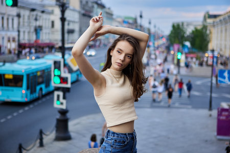 Slender 18 year woman on crowded city street of summer evening.の写真素材