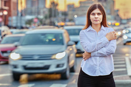 White woman 26 years old walks near traffic at evening.の写真素材