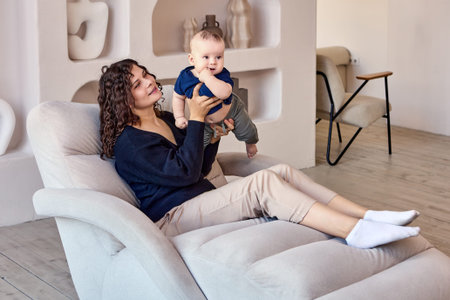 Couch in living room with woman who holds child.