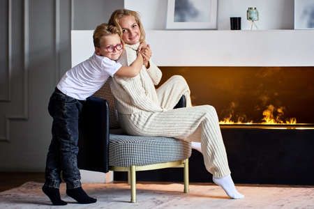 Electric fireplace with happy woman and little boy near it.の写真素材