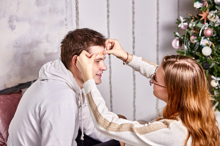 First aid for domestic injury, woman closes wound on her husband forehead with plaster.の写真素材
