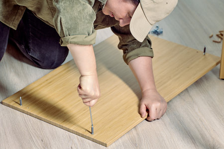 Diy assembly of flat pack furniture, mature woman screwing dowel.の写真素材