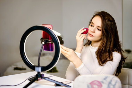 Makeup blending sponge for beauty blogger during video recording by phone.の写真素材