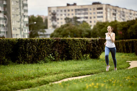 29 year old woman is jogging in city park.の写真素材