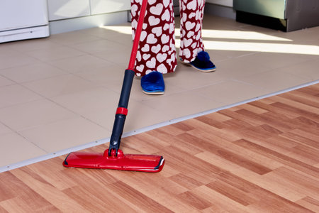 Housework with using flat mop to mopping floor in kitchen.