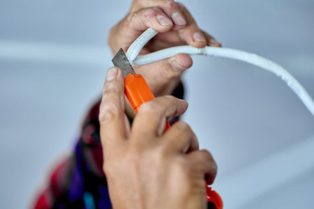 Stripping electrical wiring with utility knife that has breakable blade.