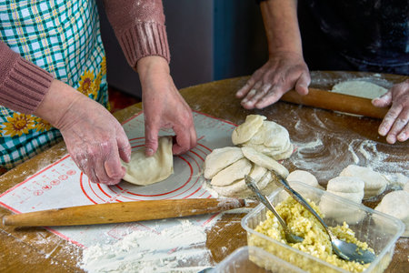 Cooking homemade pies with filling in rural house, rolling out dough, forming pie.