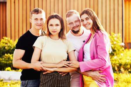 Four young people, two married couples are photographed outdoors in summer for group portrait.の写真素材
