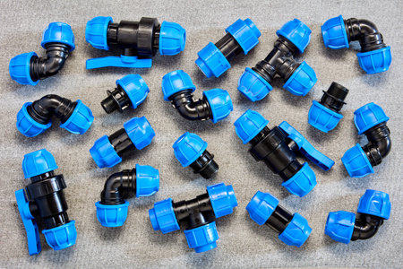 Polypropylene compression clamping fittings for pipeline system made of HDPE pipes laid out on gray...