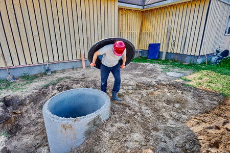 Installing composite polymer support ring or manhole base on concrete septic tank ring.の写真素材