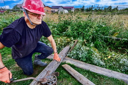 Rigging work on country site, using manual winch with gear mechanism and steel cable when moving...
