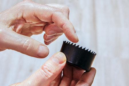 Saw tool with jagged edges used for cutting circular sections in various surfaces.