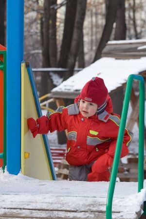 The little girl in the red rises on an ice slopeの写真素材