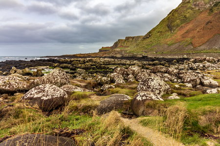 A field of large boulders found on the dramatic Causeway Coast in Northern Ireland under a cloudy skyの写真素材