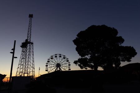 The Ferris whell at Tibidabo amusement park in silhouette at sunriseの写真素材