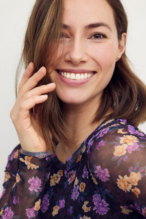 Beautiful woman smiling and looking to the left. Close-up portrait of confident female looking cute,  isolated on white background.の写真素材